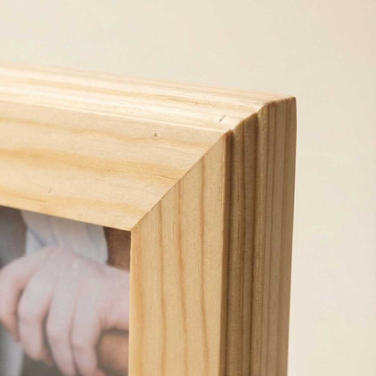Close-up of natural wood picture frame corner with visible wood grain detail