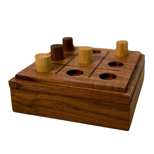 Handmade wooden tic-tac-toe game with natural wood finish and cylindrical playing pieces on a wooden box