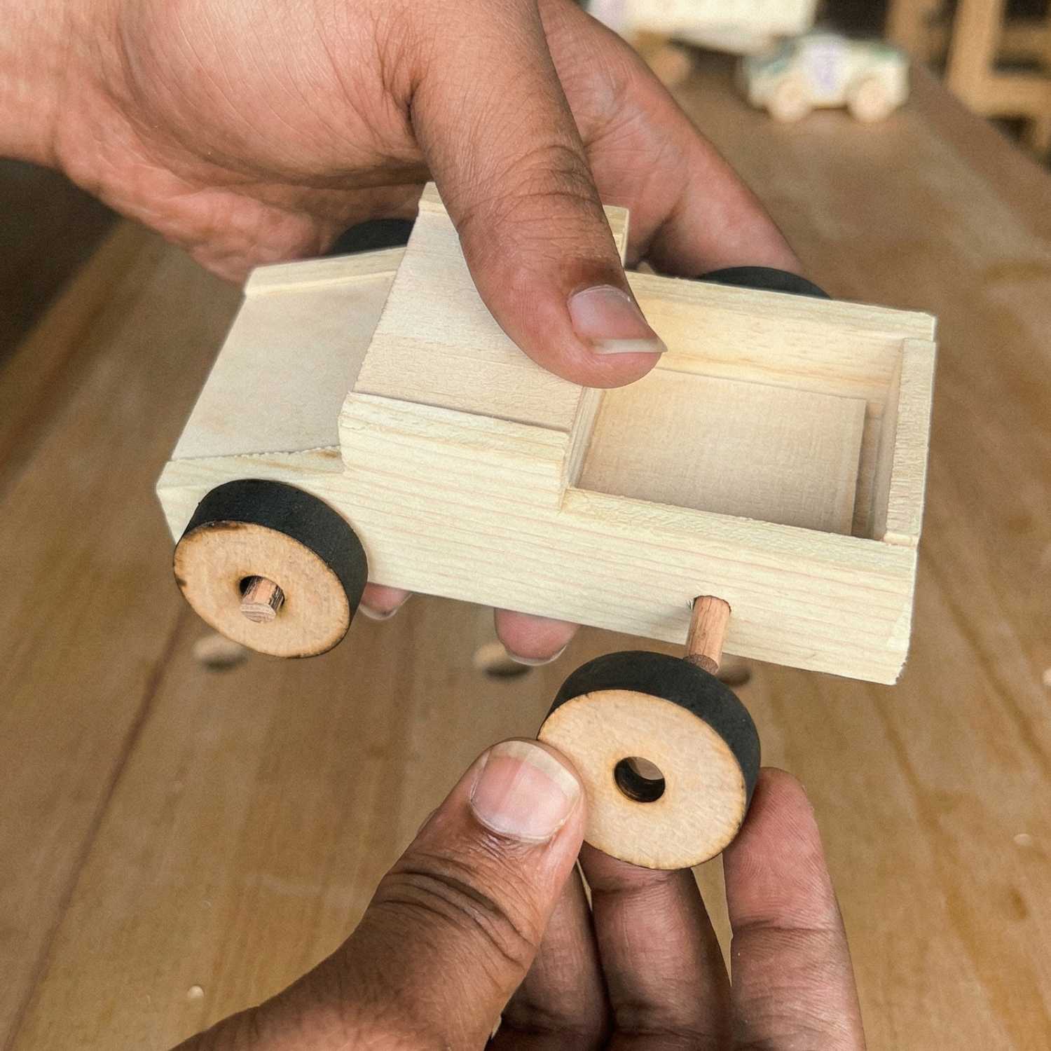 Attaching a wooden wheel to a race car from The Makers Society kids woodworking kit