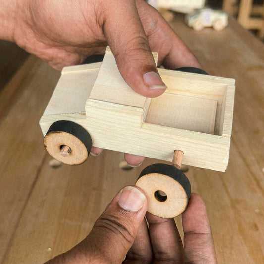 Attaching a wooden wheel to a race car from The Makers Society kids woodworking kit