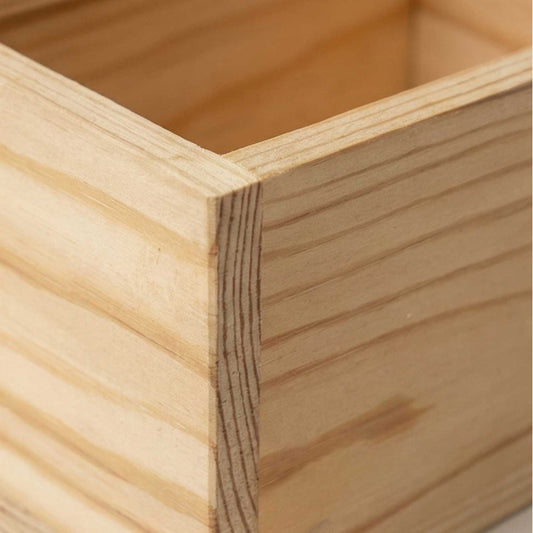 Macro close-up of the corner joinery and natural pine wood grain of a handcrafted wooden box, highlighting the smooth finish and craftsmanship.