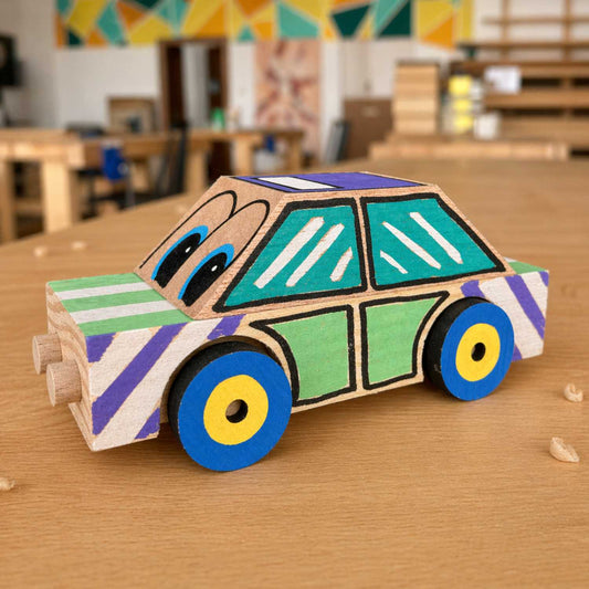 Finished wooden taxi car kit by The Makers Society in a side view showing the painted body, windows, and wheels.