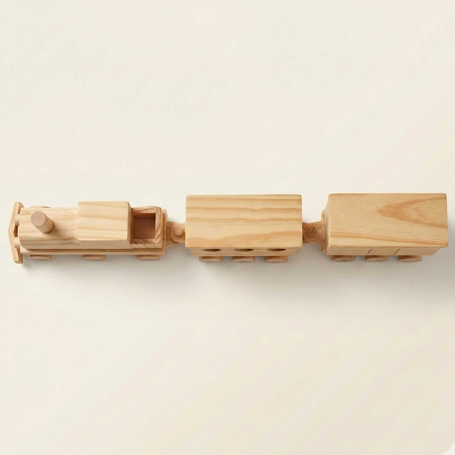 Handmade wooden toy train three-car set on a light background, top-down view