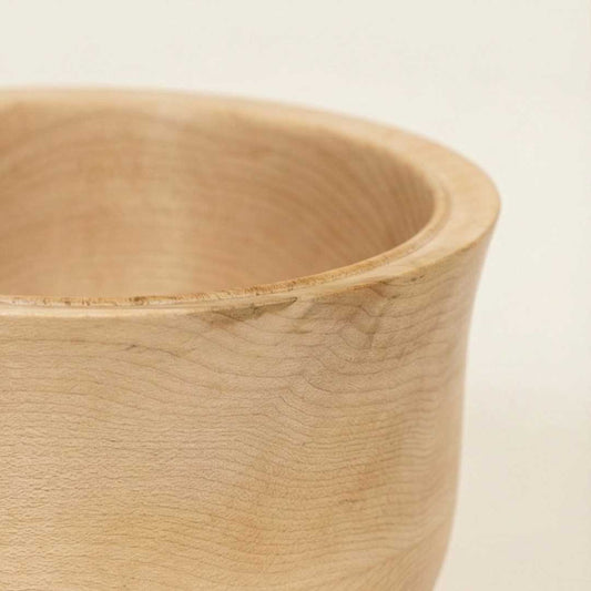 Close-up of a wooden bowl on a light beige background made at the woodturning course at The Makers Society Dubai