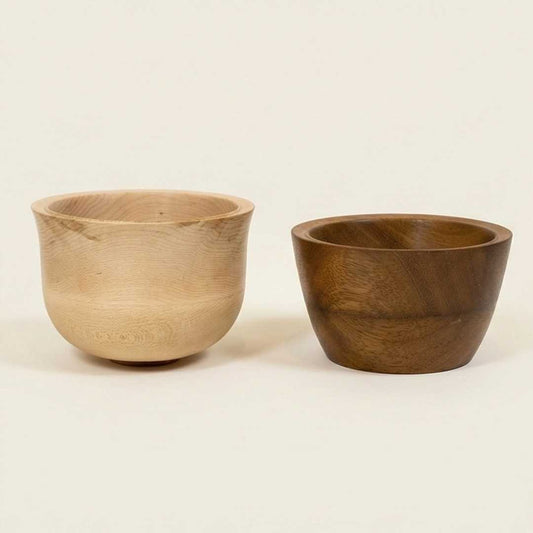 Two wooden bowls, one light brown and one dark brown, on a beige background made at the woodturning course at The Makers Society Dubai